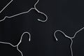 White hangers on black paper background. Minimalistic fashion concept. Royalty Free Stock Photo