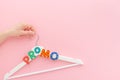 White hangers with promo text on pink background