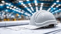 The white hard hat rests on detailed blueprint plans, representing construction and engineering ideas set against a Royalty Free Stock Photo