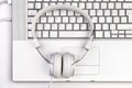 White headfones on silver laptop. Royalty Free Stock Photo