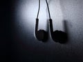 White earphone with light on dark background Royalty Free Stock Photo