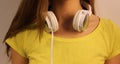 White headphones close-up hanging on the neck of the young girl in a yellow T-shirt Royalty Free Stock Photo