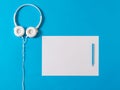 White headphones, a white piece of paper and a blue marker on a blue background. Royalty Free Stock Photo