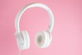 White headphones on pink background. Music concept