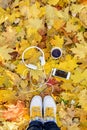 White headphones with a player and a cup of tea and coffee on a background of yellow leaves.