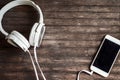 White headphones and smartphone on wooden background. Flat lay composition for banner Royalty Free Stock Photo