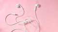 White headphones with wires on a pink background Royalty Free Stock Photo