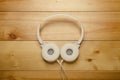 White headphones on wooden table. Modern headphone with cable