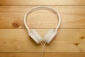 White headphones on wooden table. Modern headphone with cable