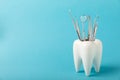 White healthy tooth and various dental tools for dental care