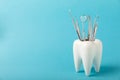 White healthy tooth and various dental tools for dental care.