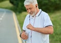 White-heared senior man opening water bottle during morning scamper.