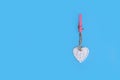 White heart attached with laundry clip on blue background Royalty Free Stock Photo