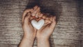 White heart in child hands on old rustic wooden table in vintage retro style Royalty Free Stock Photo