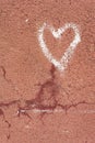 White heart drawn on a red cracked wall