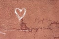 White heart drawn on a red cracked wall