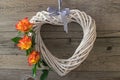 A white heart made of grapevine, decorated with beautiful orange roses. Royalty Free Stock Photo
