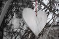 White heart with red ribbon outdoor, black and white. Hanging wooden heart, monochrome. Romance and love concept. Valentines day.