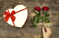 White heart shaped box and hand woman holding a red rose flower for holidays, valentine`s or mother`s or women`s day Royalty Free Stock Photo