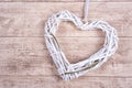 White heart from wickerwork with grass on wooden background Royalty Free Stock Photo
