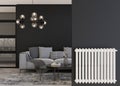 White heating radiator on black wall in modern room. Home interior. Central heating system. Heating is getting more