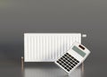 White heating radiator and calculator on gray background. Central heating system. Free, copy space for your text