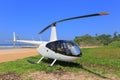 White helicopter Robinson R44 on the beach