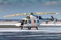 White helicopter with an open engine on the winter airport apron Royalty Free Stock Photo