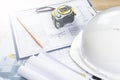 white helmet and tape measure, pencil ruler and construction drawings, selective focus Royalty Free Stock Photo