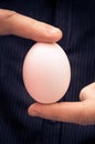 White hen egg held fingers Royalty Free Stock Photo