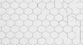 White hexagonal tiles are arranged in a uniform pattern. Lines separate each hexagon Royalty Free Stock Photo