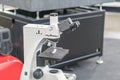 A white, high-powered optical microscope on a movable base in a laboratory setting, under directional lighting The background Royalty Free Stock Photo