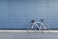 White highway bike stands on the background of a blue wall. Sports concept