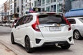 White Honda Fit on the road in the city with traffic