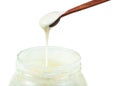 White honey pouring from wooden spoon in glass jar Royalty Free Stock Photo