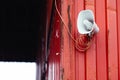 White horn loudspeaker mounted on the building's red wall Royalty Free Stock Photo