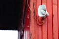 White horn loudspeaker mounted on the building's red wall