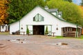 White horse barn wuth green shatters. Royalty Free Stock Photo