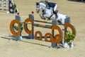 White horse jumping the obstacle durign a five star competition