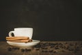 White hot cup of coffee and sticks of cinnamon/white hot cup of coffee and sticks cinnamon on a dark wooden background. Copy space Royalty Free Stock Photo