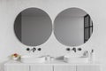 White hotel bathroom interior with double sink and mirror, accessories on deck Royalty Free Stock Photo