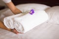 House keeper places towels on a clean white bed for room service