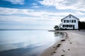 white house with black shutters on a serene beach, calm sea Royalty Free Stock Photo