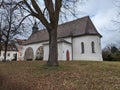 White house with brown roof by a tree with fallen leaves on the ground: Linz, Austria Royalty Free Stock Photo