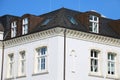 White house exterior with a dark brown roof on a clear blue sky background Royalty Free Stock Photo