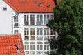 White house and hotel with many windows, red roof tile and old big tree Royalty Free Stock Photo