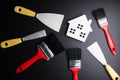 White house toy and paint brush, painters equipment on black background with copy space.Real estate concept, New house concept, F Royalty Free Stock Photo