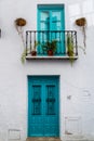 White house with turquoise, aqua marine door and windows.