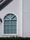 A white house window with glass, curved frame.