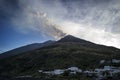 White houses at the foot of a smoking volcano